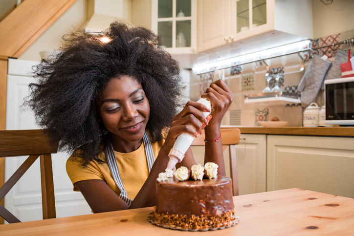Woman decorating chocolate cake at home