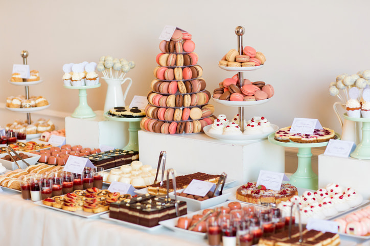 Dessert table with macarons, cake pops and bite sized cakes and pies